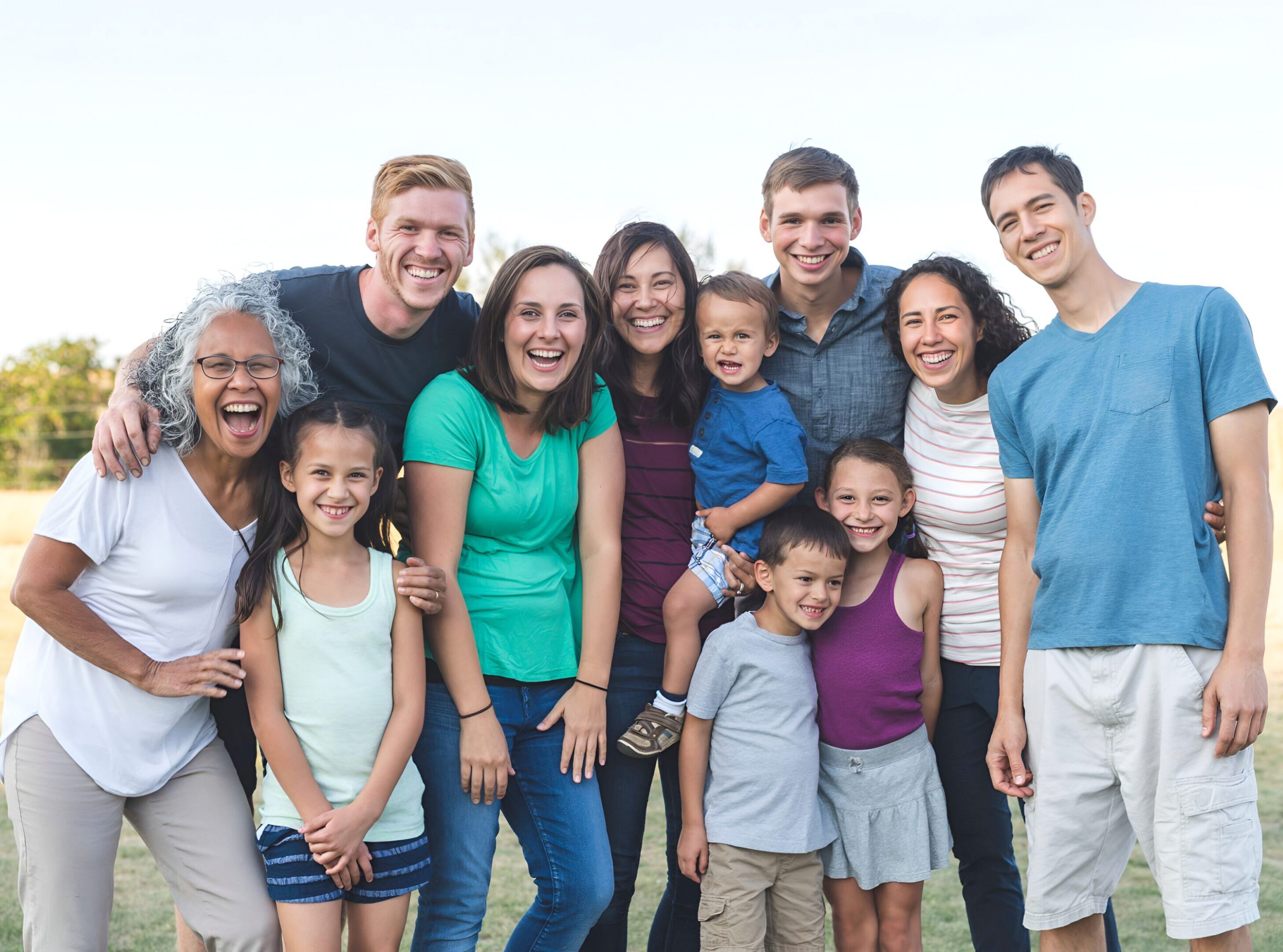 Smiling family group posing outdoors together.